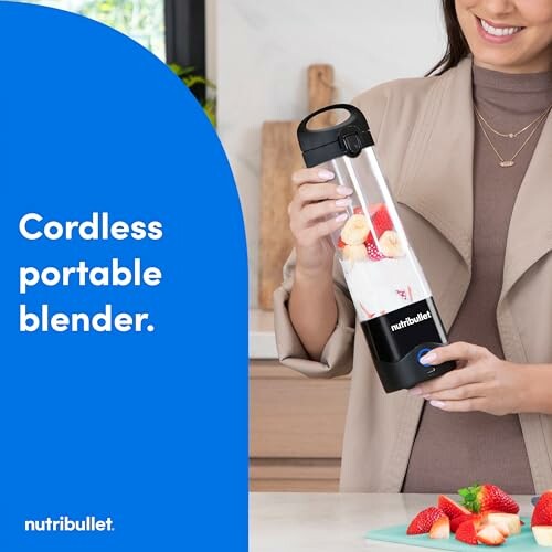 Person using Nutribullet cordless portable blender with strawberries.
