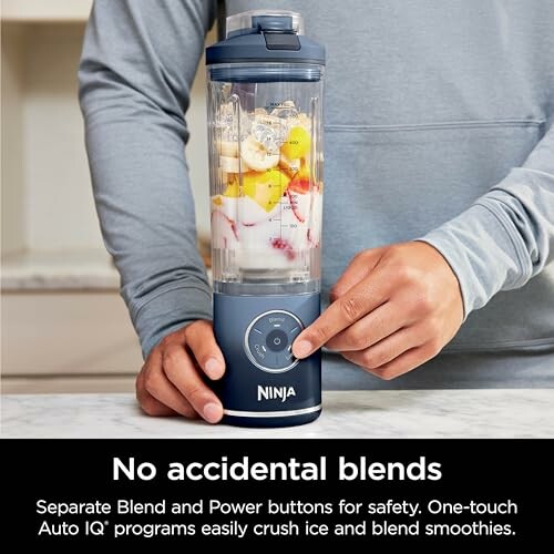 Person using a Ninja blender with fruit inside.