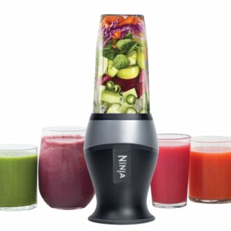 Ninja blender with mixed fruits and four colorful juices.