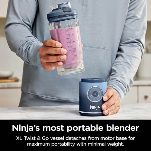 Person holding a Ninja portable blender with a smoothie.