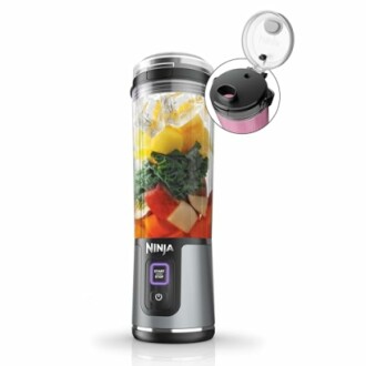 Portable blender filled with fruits and vegetables.