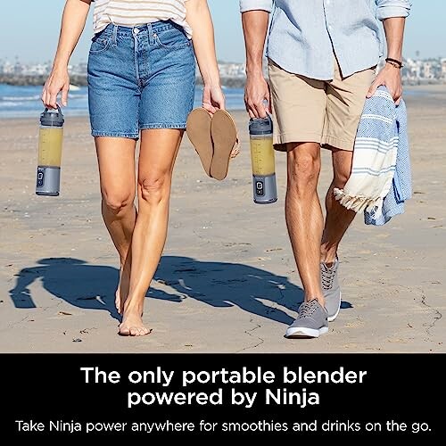 Two people walking on a beach carrying Ninja portable blenders.